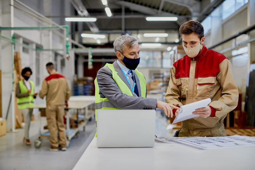 mid-adult-engineer-male-worker-wearing-face-masks-while-examining-paperwork-woodworking-factory-min